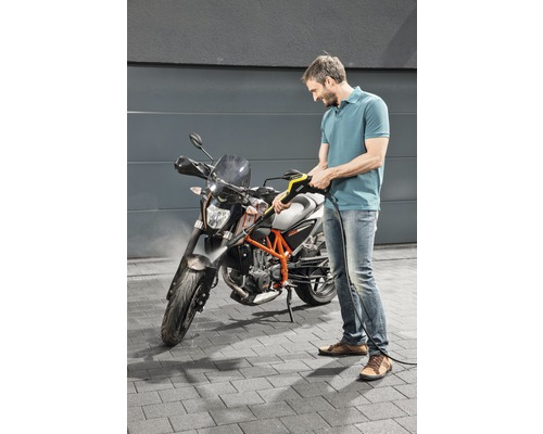 Man rengör motorcykel med högtryckstvätt