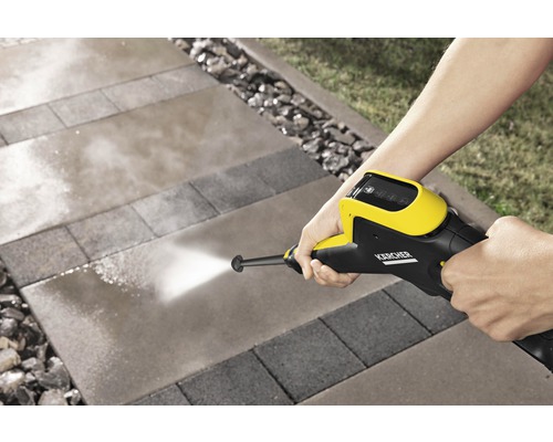 Person rengör stenplattor med en Kärcher högtryckstvätt