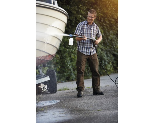 Man rengör en båt med en högtryckstvätt.