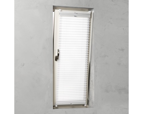 Vit plisségardin på fönstret för ljuskontroll och integritet