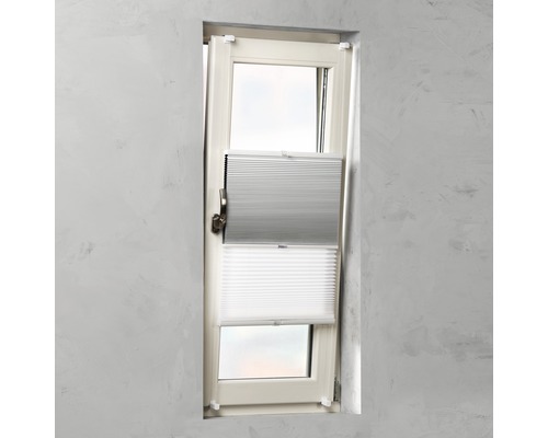 Fönster med grå och vit plisségardin