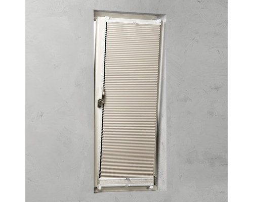 Plisségardin monterad på ett fönster.