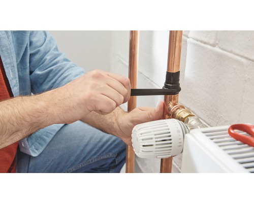 Person som reparerar kopparrör med rörtång