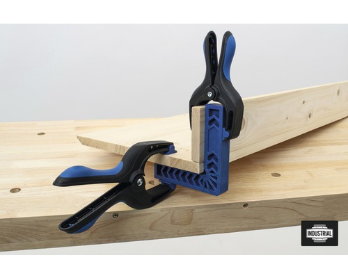 Två arbetsstyckesklämmor håller träbitar på en arbetsbänk