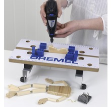 Dremel multifunktionsverktyg i drift med arbetsstycke och tillbehör på en arbetsbänk