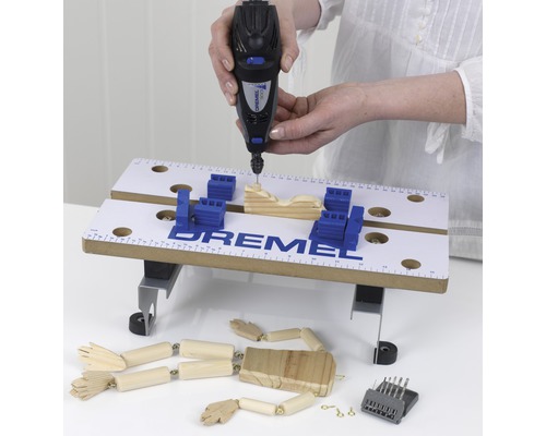 Dremel multifunktionsverktyg i drift med arbetsstycke och tillbehör på en arbetsbänk