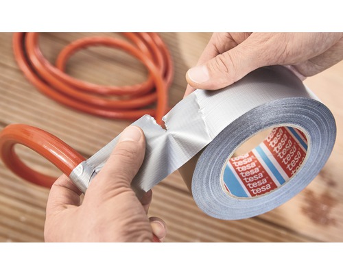 En person reparerar en slang med Tesa vävtejp.