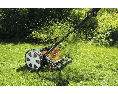 Manuell gräsklippare som klipper gräset i trädgården