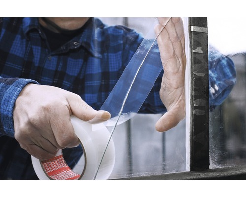 Applicering av dubbelhäftande tejp på en glasskiva.