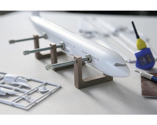 Modellflygplan under konstruktion med verktyg och lim