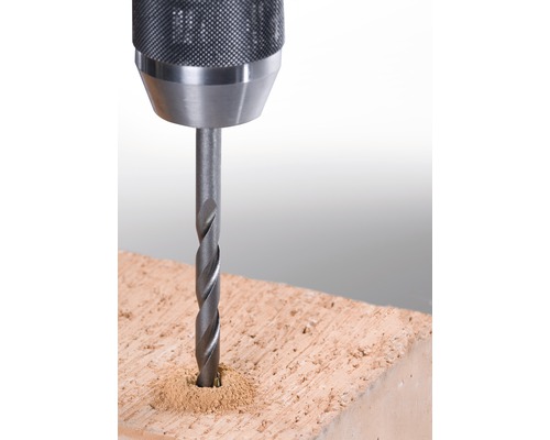 Närbild av en borr som borrar i en tegelsten.