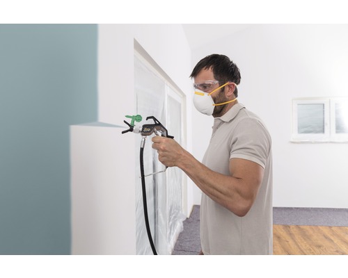 Man använder färgspruta inomhus