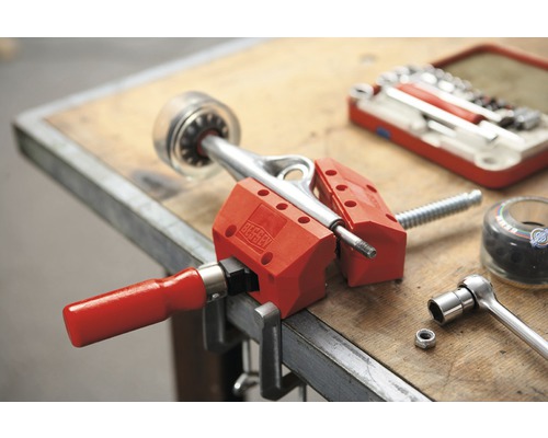 Skateboardaxel fastspänd i skruvstäd på en arbetsbänk