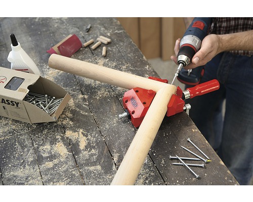 Verkstadsscen med vinkelklämma, skruvar, pluggar och sladdlös skruvdragare för träbearbetning