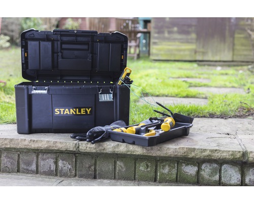 Öppen Stanley verktygslåda med verktyg och handskar