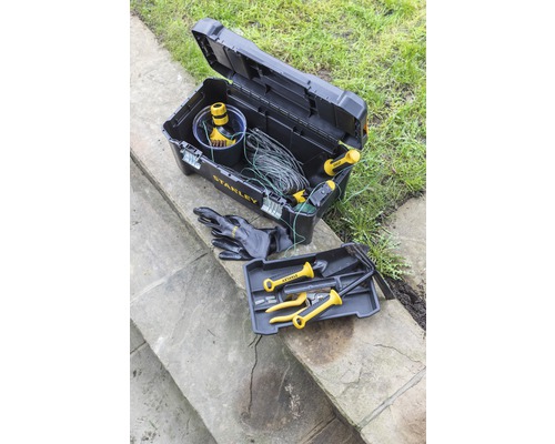 Öppen svart verktygslåda med verktyg och Stanley Logo på stentrappor