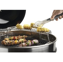 Grill med majskolvar, grillspett och en person som använder grilltång.