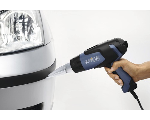 En person använder en varmluftspistol av märket Steinel på en bilstötfångare.