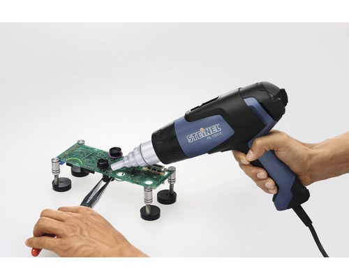 Värmepistol vid lödning av ett kretskort med en pincett och ett fäste