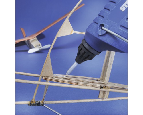 Smältlimpistol vid limning av ett modellflygplan