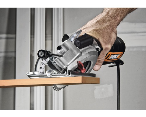 Hand som använder en Worx handcirkelsåg för att såga en träbit