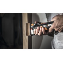 En man använder ett Worx multiverktyg för träbearbetning.