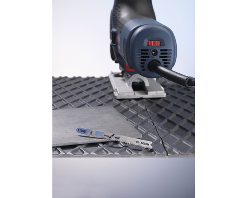 Sticksåg och sågblad som skär en kakelplatta