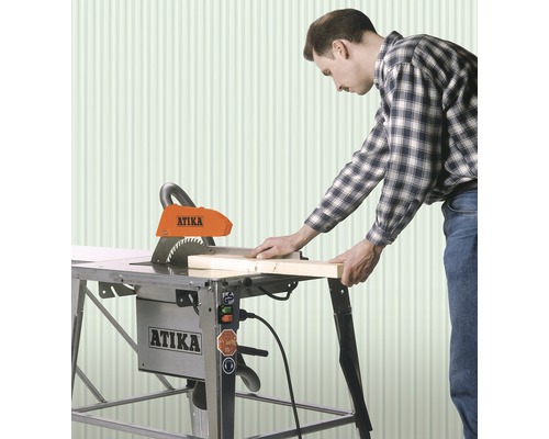 Man arbetar med en Atika bordsåg för att skära trä.