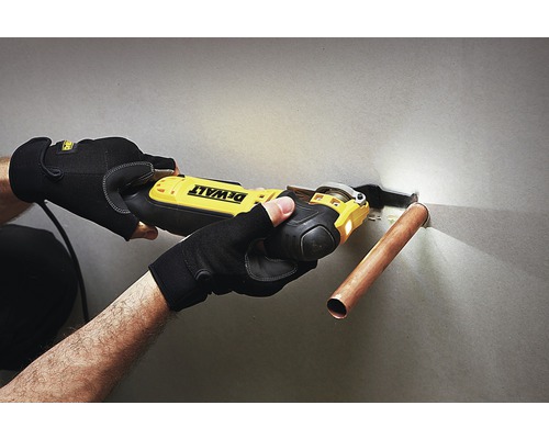 En person använder en oscillerande såg från Dewalt för att kapa ett kopparrör.