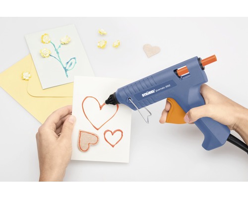 Smältlimpistol applicerar lim på ett kort