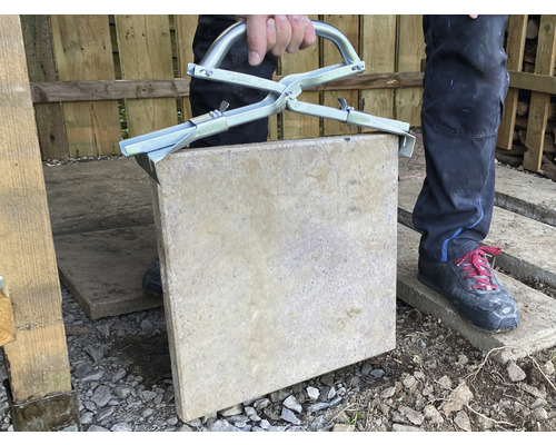 Man lyfter trottoarplatta med stenklämma