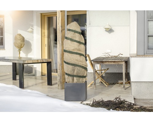 Terrass med växtskyddssäckar och trädgårdsbord på vintern.