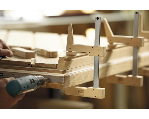 Hantverkare monterar trädörr med skruvtvingar och skruvdragare