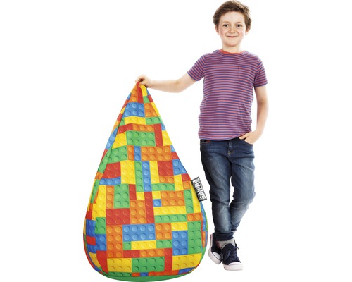 Pojke bredvid en sittsäck med färgglatt byggstensmönster