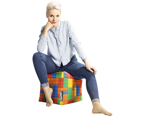 Kvinna sitter på sittkub med byggklossdesign