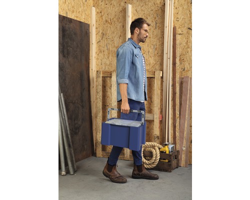 Man bär en verktygslåda i en verkstad