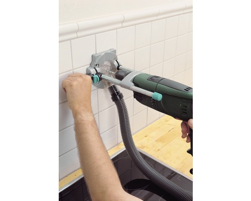 Kakelborrningshjälp med borrmaskin som används för att borra hål i kakel