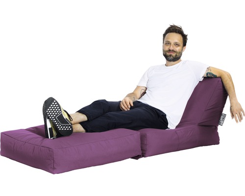 Man kopplar av på en lila sittö med fotpall.