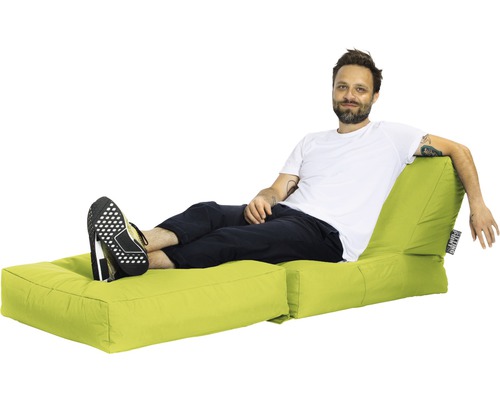 Man kopplar av på en ljus sittpuff med fotpall