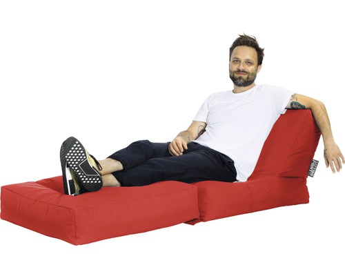 Man kopplar av på en röd sittsäck med fotstöd