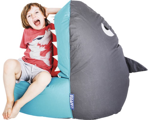 Pojke sitter på en sittsäck formad som en haj