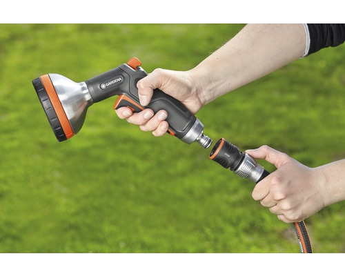 Person ansluter Gardena dusch till trädgårdsslang