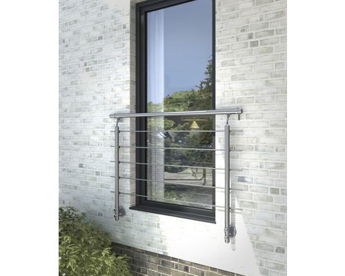 Fönster med rostfritt räcke framför en tegelvägg