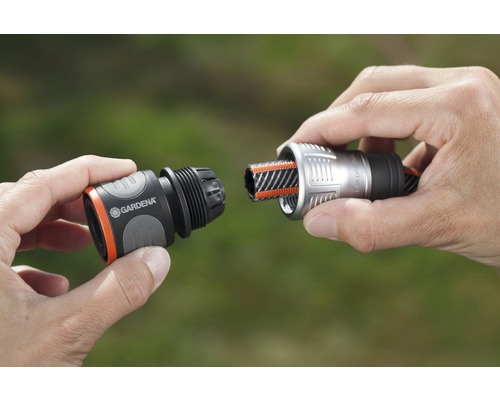 Trädgårdsslangkoppling är ansluten av händer