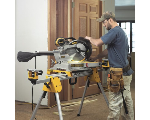 En kap- och gersåg med en arbetare på en byggarbetsplats som sågar trä.