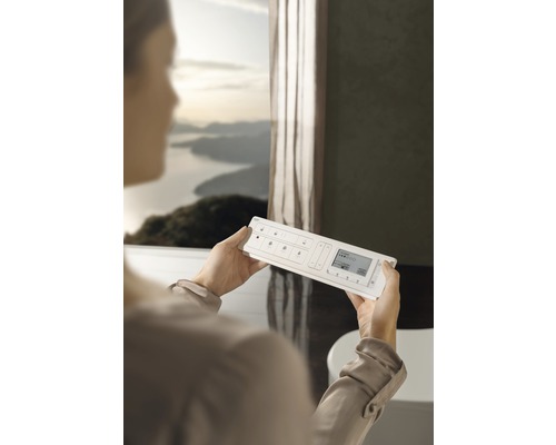 Kvinna håller ett hemautomationssystem i ett badrum.
