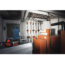 Batteridriven lampa framför installationer i pannrummet