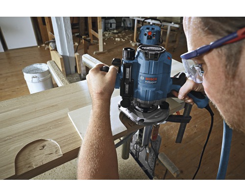 Hantverkare i verkstad som bearbetar trä med en överfräs