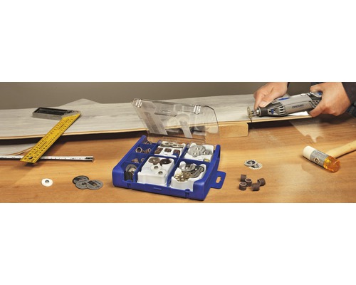 Dremel verktyg med tillbehörslåda, vinkelhake, måttband och hammare på ett bord