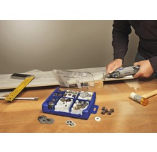 Dremel multiverktyg i bruk med tillbehörssats på en arbetsbänk i trä